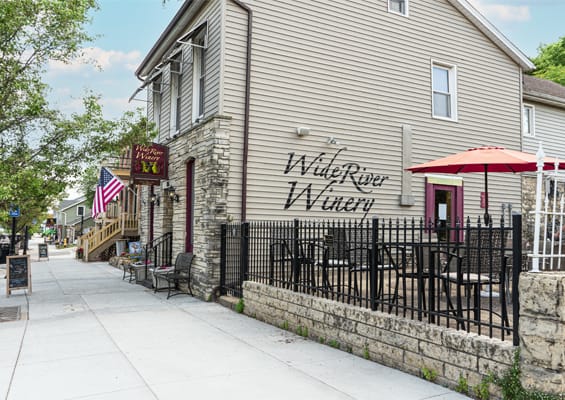 Wide River Winery's outdoor seating in LeClaire, Iowa with views of the Mississippi River.